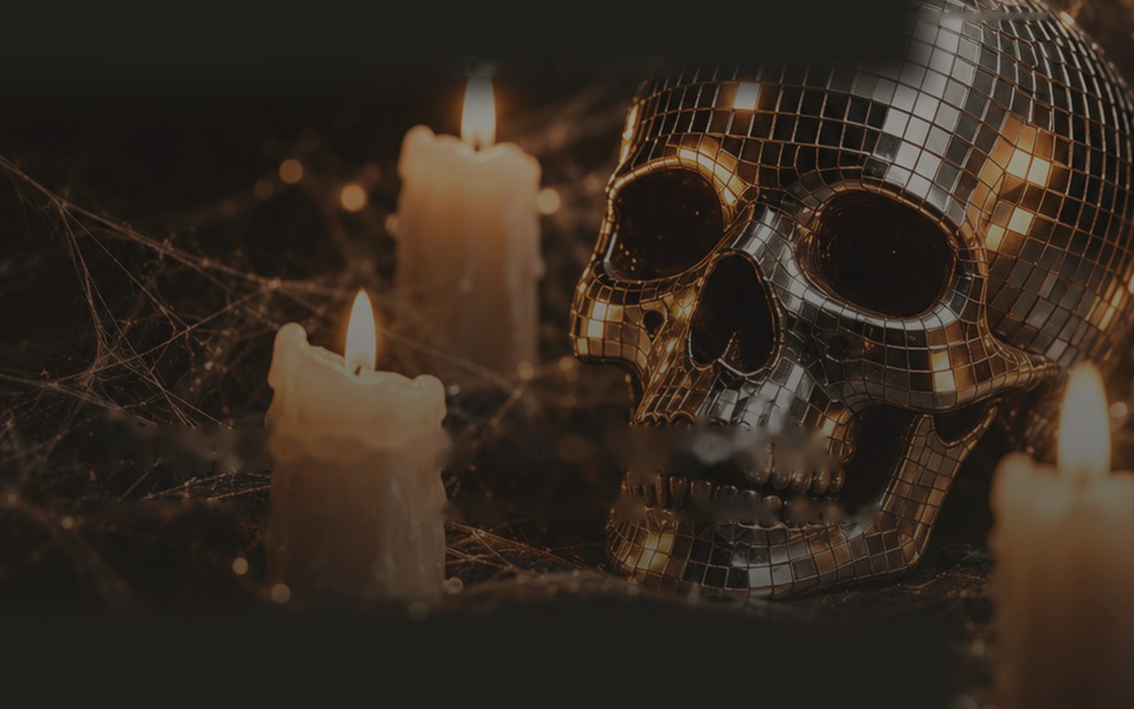 Un teschio rivestito di specchi fra candele accese e ragnatele, la foto della locandina della festa di Halloween